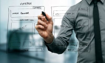 Business professional designing website layout on transparent board, emphasizing web design importan.