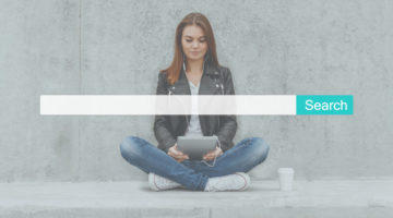 Woman sitting on ground using tablet with search bar, illustrating SEO fears and concerns.