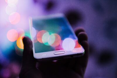 Smartphone displaying vibrant, colorful bokeh lights, symbolizing digital marketing and online engag.