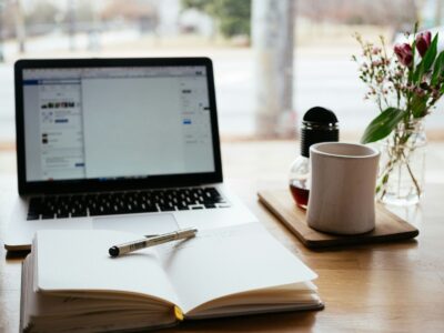 Modern workspace with laptop, notebook, and flowers, emphasizing web design and SEO for event planni.